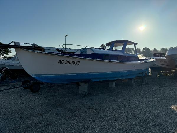 Custom Eyquem 1955 Custom Eyquem boat on land, blue and white hull, registration AC 300933.