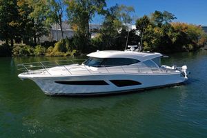 Riviera 465 SUV 2025 Riviera 465 SUV yacht cruising on a serene river.