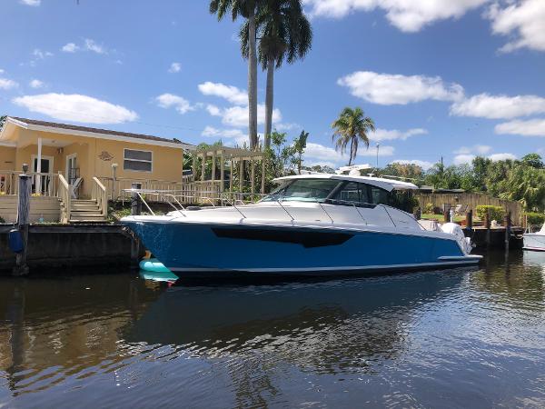 Tiara Yachts 43 LE 2021 Tiara Yachts 43 LE docked by a waterfront house under a sunny sky.
