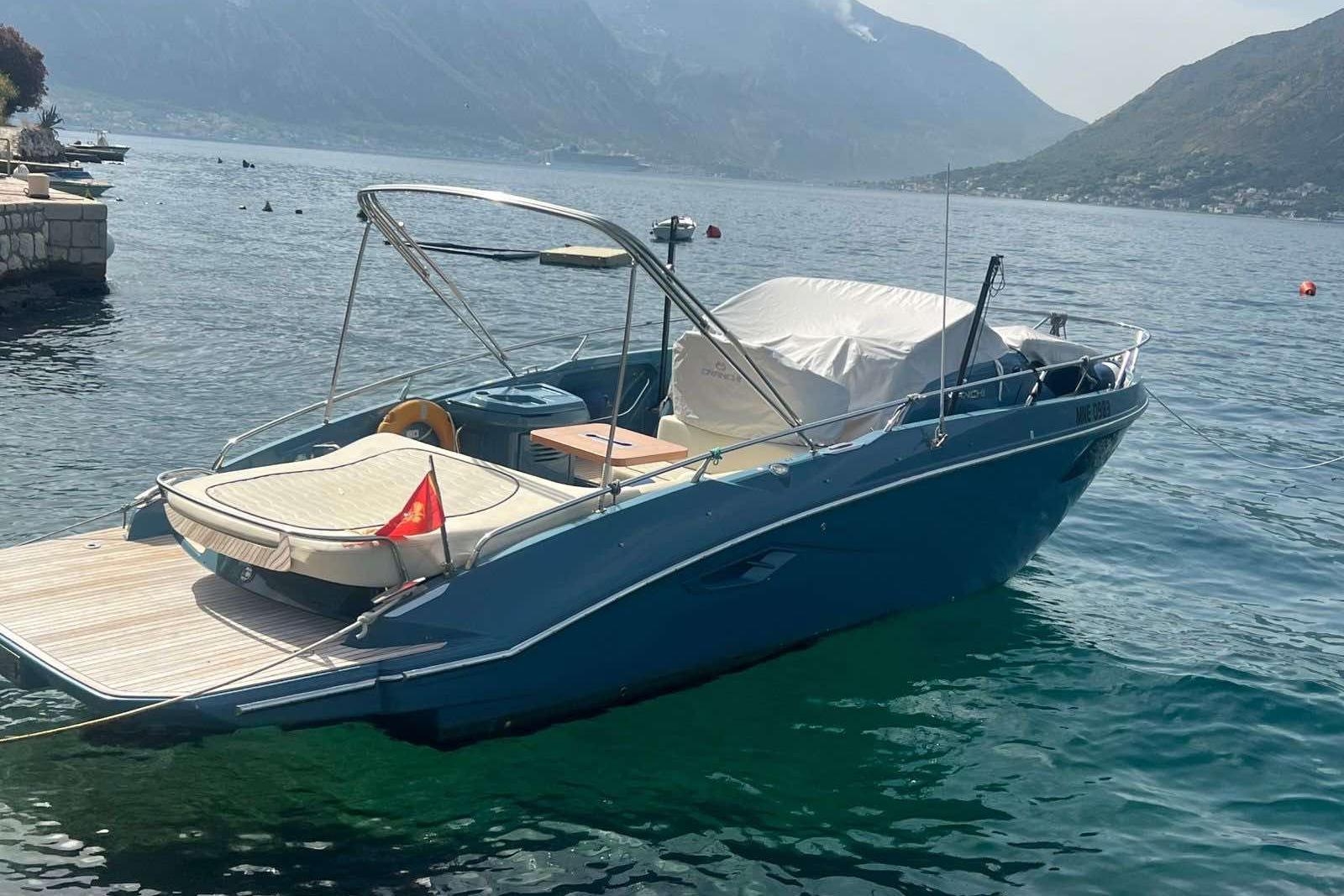 Cranchi E30 Endurance 2021 Cranchi E30 boat docked on a serene lake with mountainous backdrop.