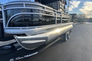Sun Tracker SportFish 22 DLX 2026 Sun Tracker SportFish 22 DLX pontoon boat on trailer, outdoor setting.