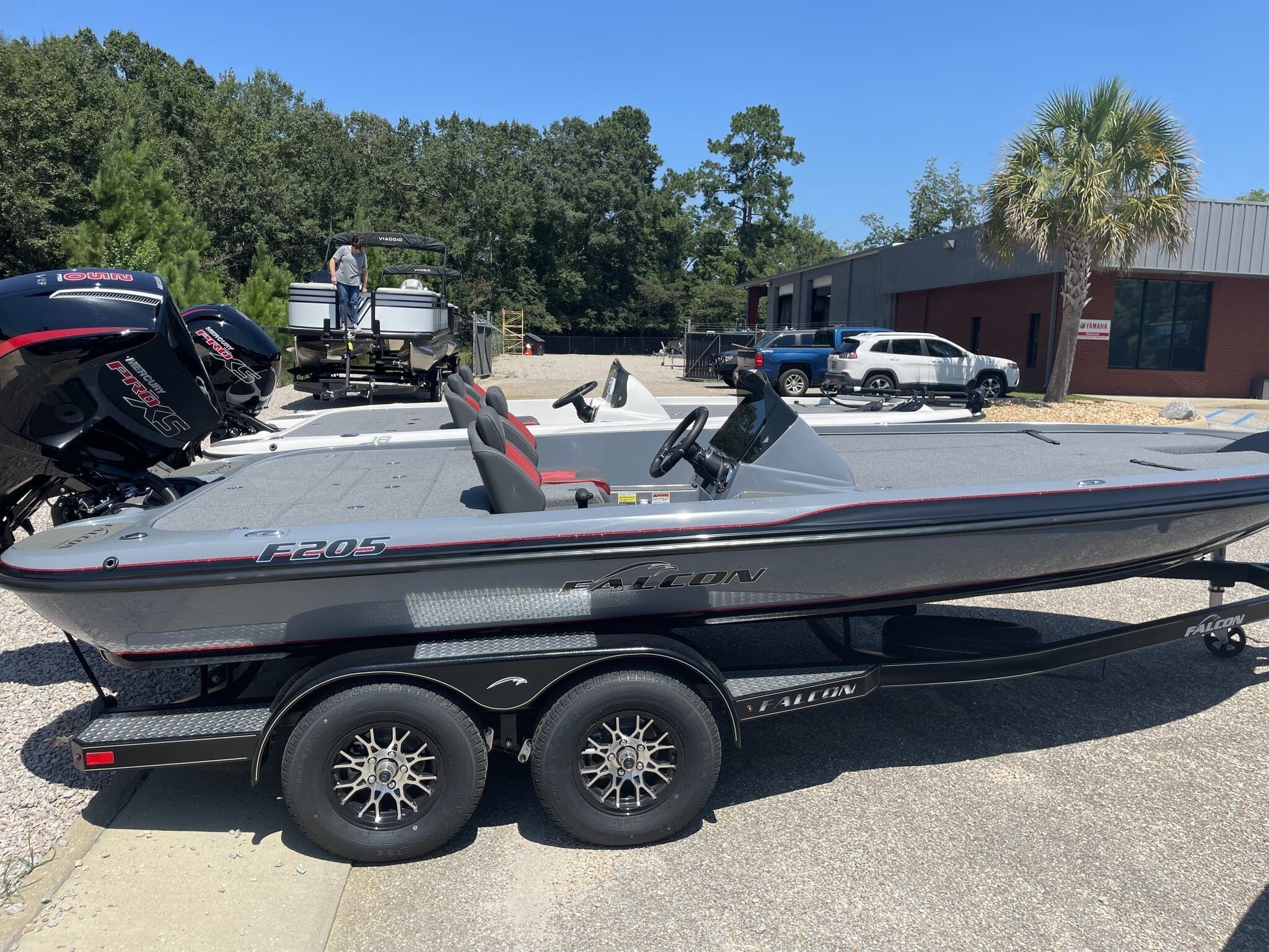 Falcon F205 2025 Falcon F205 boat on trailer, parked outdoors near trees and buildings.