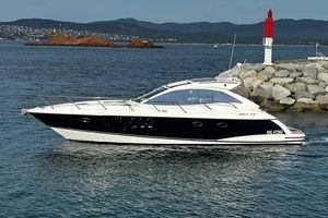 Absolute 47 HT Luxury 2011 Absolute 47 HT yacht cruising near rocky shoreline and lighthouse.
