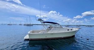Mainship 30 Pilot Rum Runner 2004 Mainship 30 Pilot Rum Runner boat on calm water under blue sky.