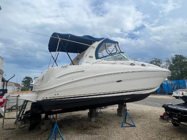Sea Ray 300 Sundancer 2002 Sea Ray 300 Sundancer boat on stands, blue canopy, outdoor storage.