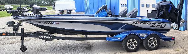 Nitro Z20 2021 Nitro Z20 boat on trailer, blue and white, parked near blue building.