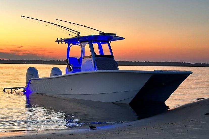Freeman 28 2024 Freeman 28 boat at sunset with blue lights and fishing rods.