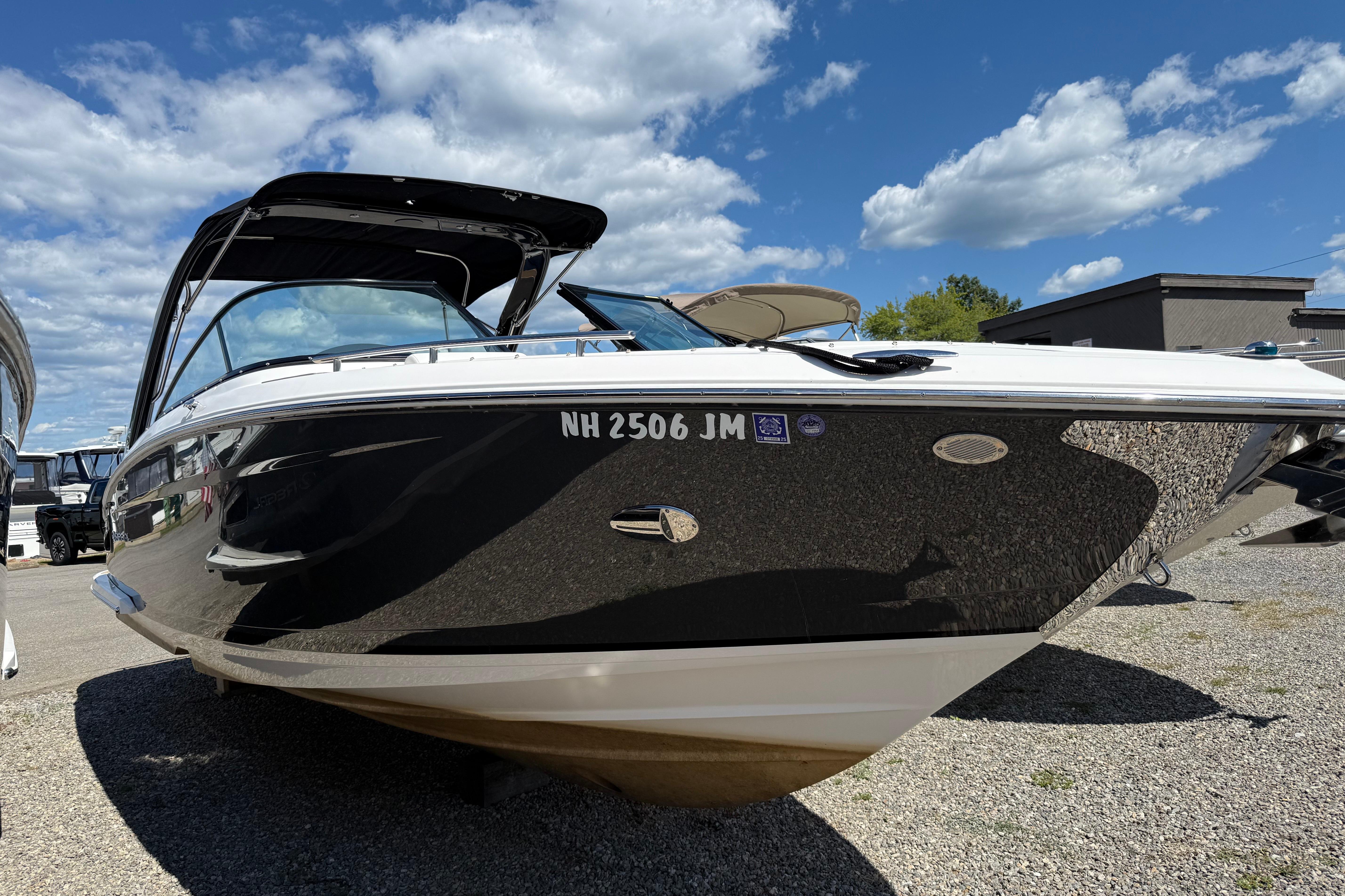 Regal 2800 Bowrider 2018 Regal 2800 Bowrider boat with sleek black hull, parked outdoors under blue sky.
