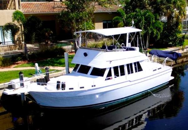 Mainship 430 Trawler 2000 Mainship 430 Trawler docked by lush greenery and waterfront homes.
