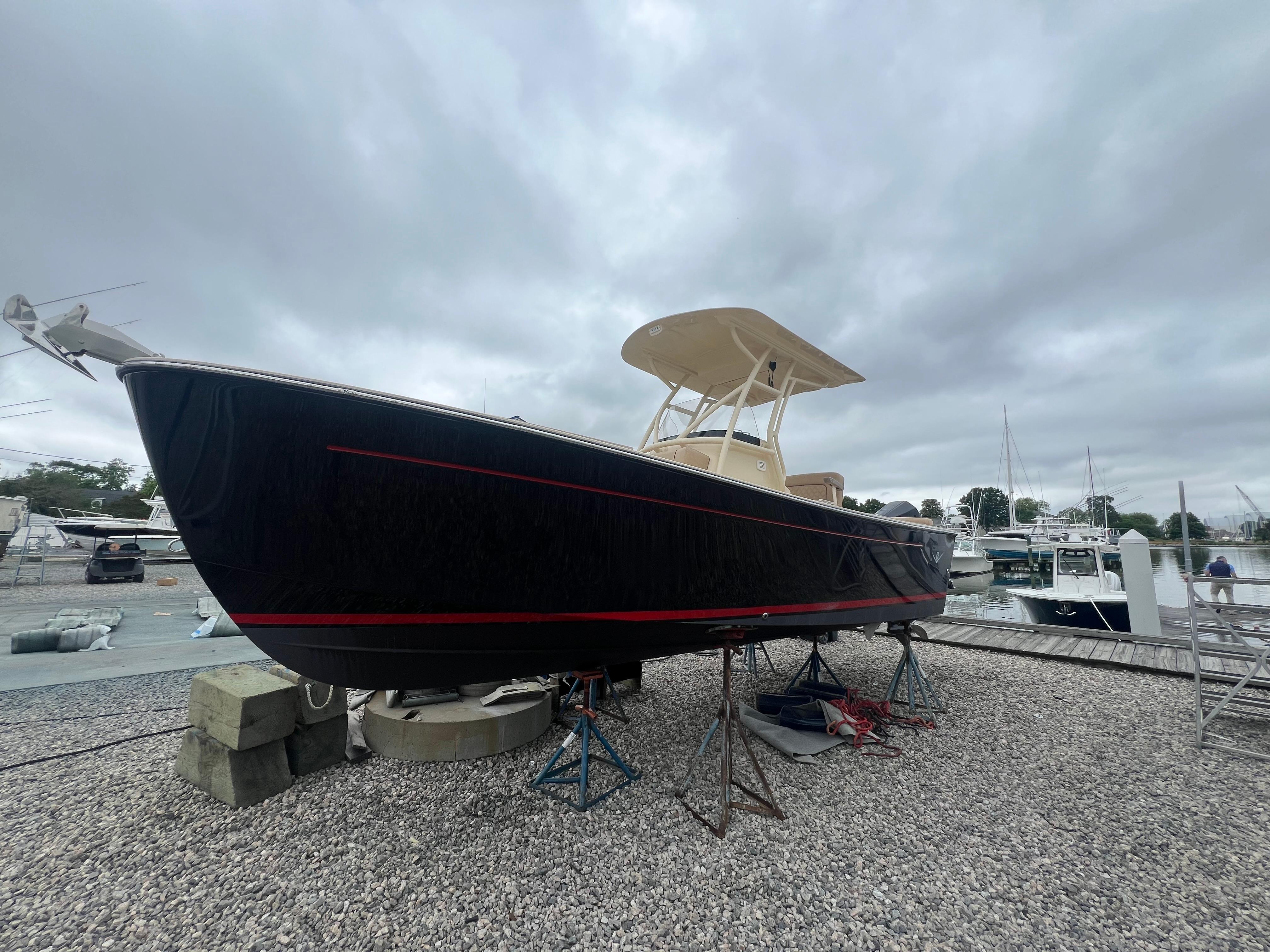 Century Coranado 23 Century Coronado 23 boat, 2020 model, on stands at a marina with overcast sky.