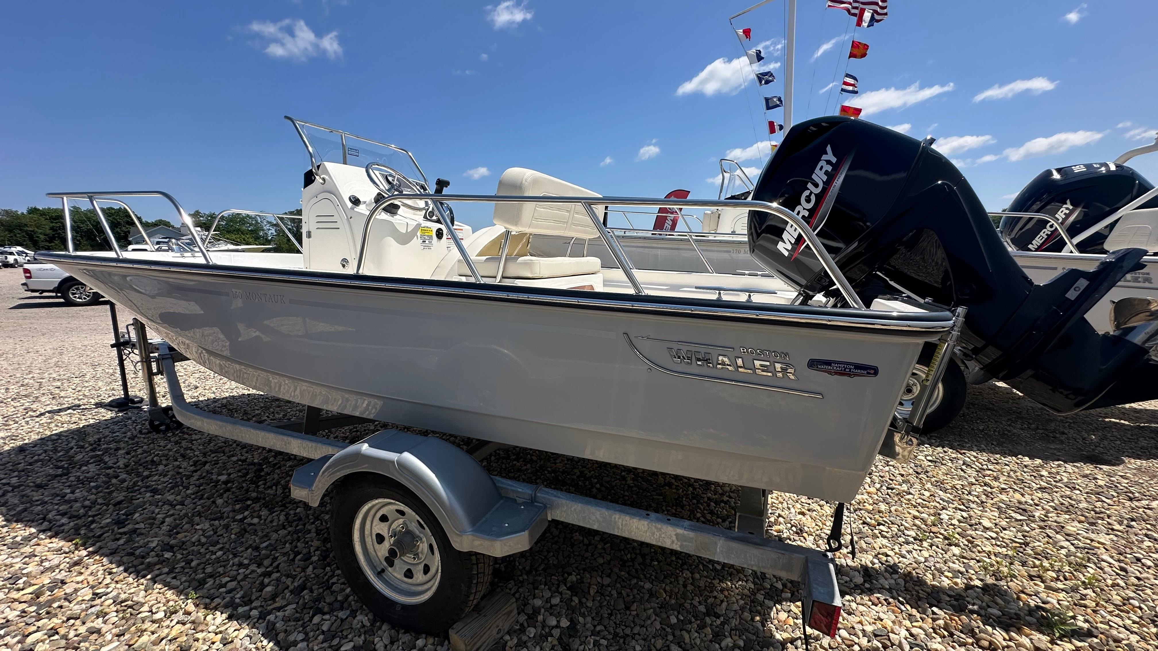 Boston Whaler 150 Montauk 2025 Boston Whaler 150 Montauk boat on trailer, displayed outdoors under clear sky.