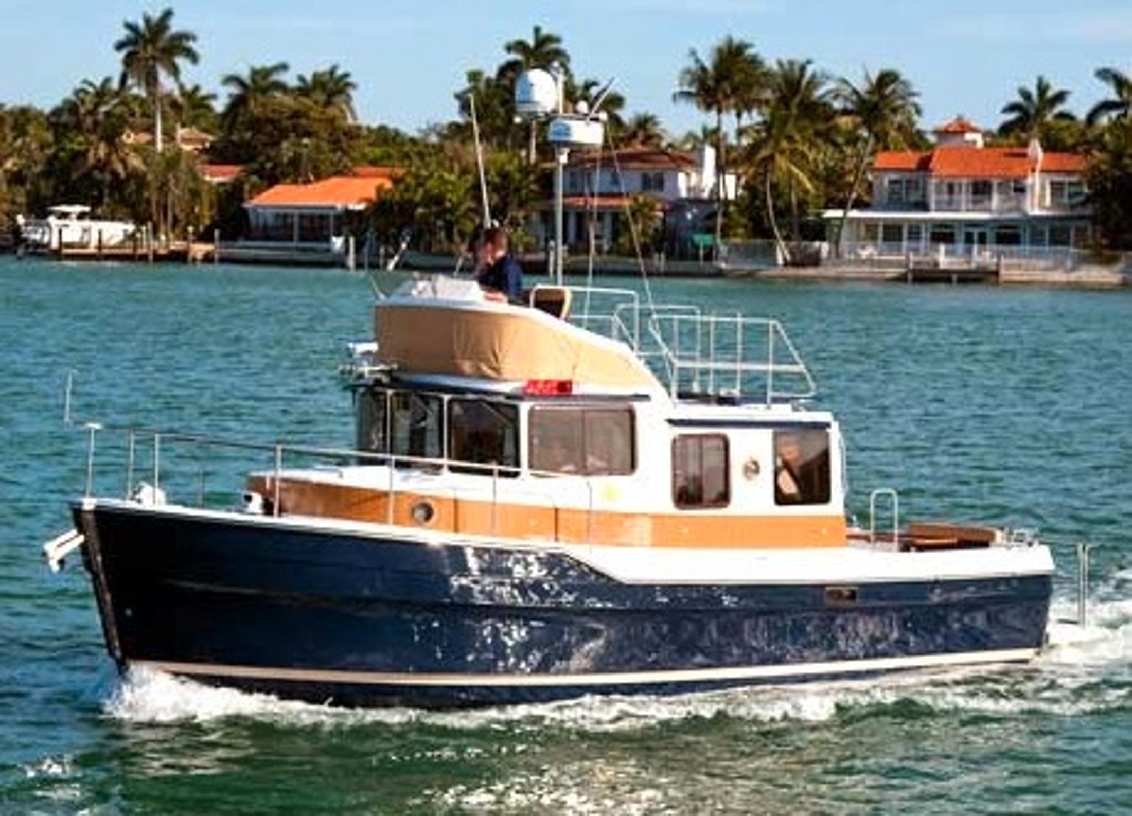Ranger Tugs R-31CB 2013 Ranger Tugs R-31CB cruising on a sunny day near waterfront homes.