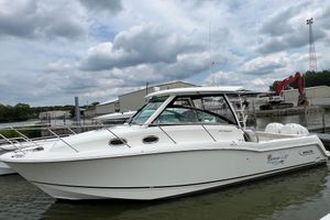 Boston Whaler 315 Conquest 2019 Boston Whaler 315 Conquest boat docked at marina under cloudy sky.