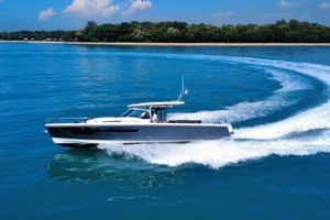 Nimbus T11 X-Edition 2023 Nimbus T11 X-Edition boat cruising on clear blue water near a lush shoreline.