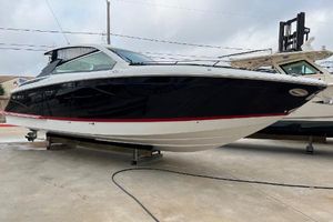 Cobalt A36 2018 Cobalt A36 boat on display, black and white exterior, docked on a concrete surface.