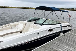 Sea Ray 280 Sundeck 2013 Sea Ray 280 Sundeck boat docked by the water, featuring a blue canopy.