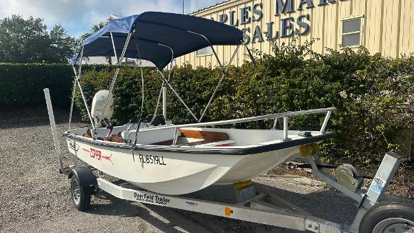 Boston Whaler 13 Sport 1971 Boston Whaler 13 Sport boat on trailer with blue canopy, parked outdoors.