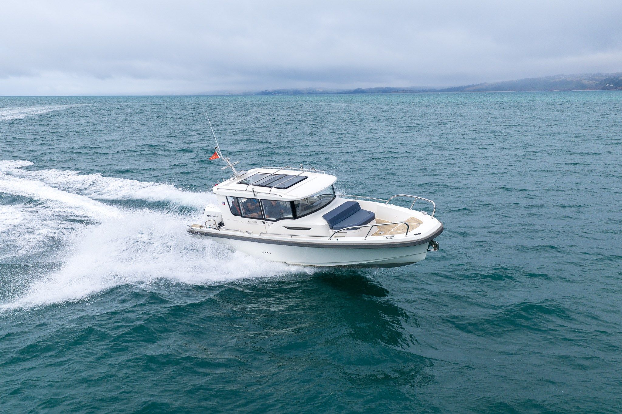 Nimbus C9 2021 Nimbus C9 boat cruising on open sea under cloudy skies.