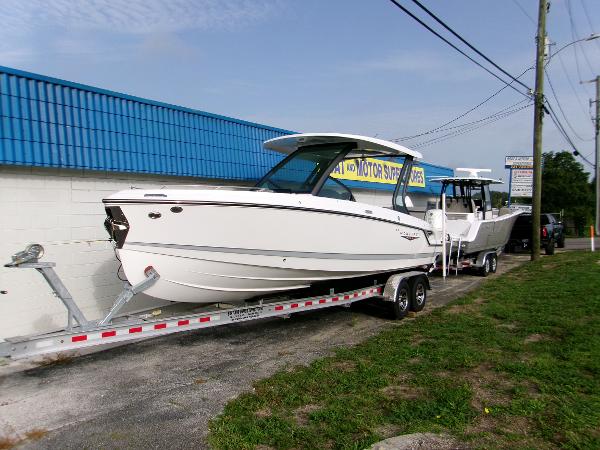 Monterey Elite 27 OB 2025 Monterey Elite 27 OB boat on trailer, parked outside a blue-roofed building.