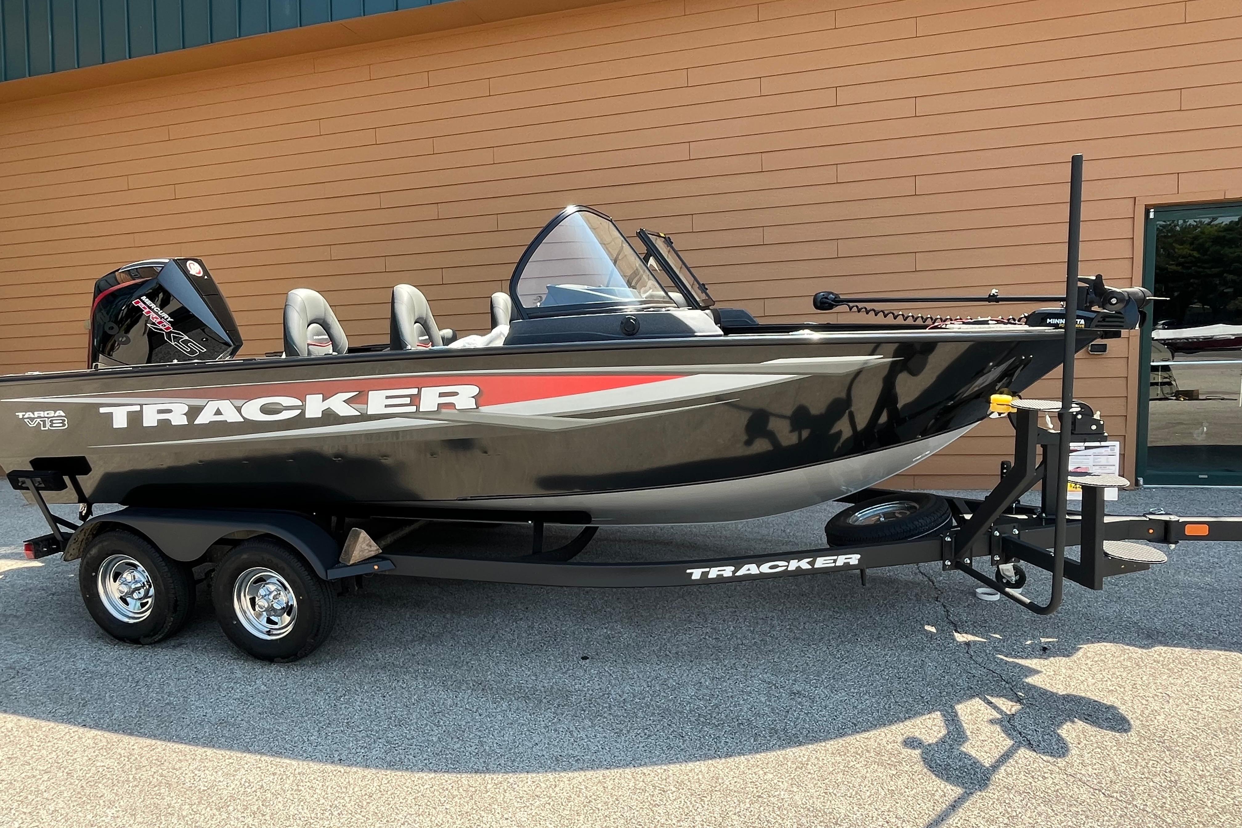 Tracker Targa V-18 Combo 2026 Tracker Targa V-18 Combo boat on trailer, black and red design, parked outdoors.
