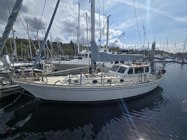 Shannon 38 PH 1980 Shannon 38 PH sailboat docked in a marina under a partly cloudy sky.