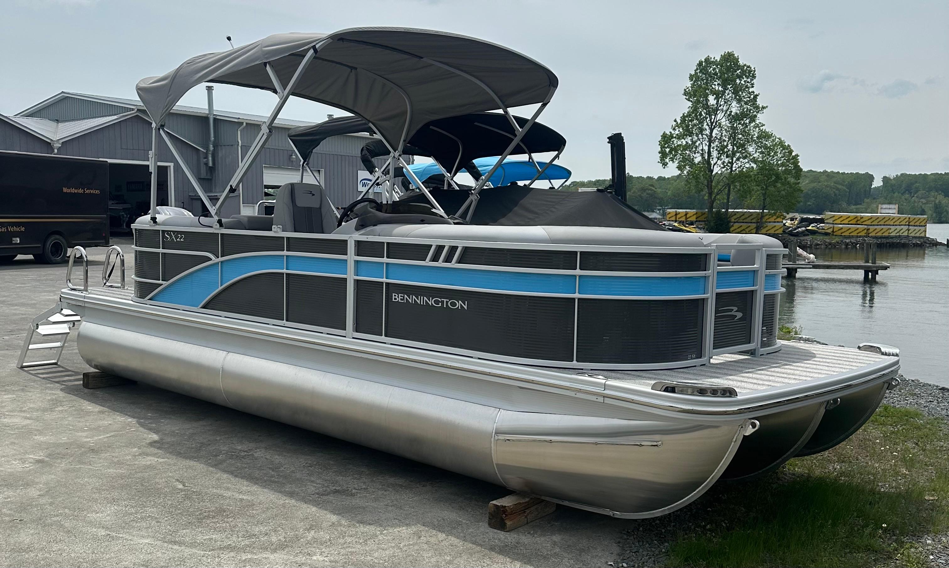 Bennington 22 SXSR 2025 Bennington 22 SXSR pontoon boat docked near a waterfront, featuring a sleek design.
