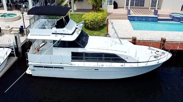 Bertram 42 Motor Yacht 1974 Bertram 42 Motor Yacht docked near a luxurious waterfront property.
