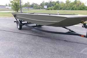 Tracker Grizzly 1860 Utility 2026 Tracker Grizzly 1860 Utility boat on trailer, parked on asphalt road.