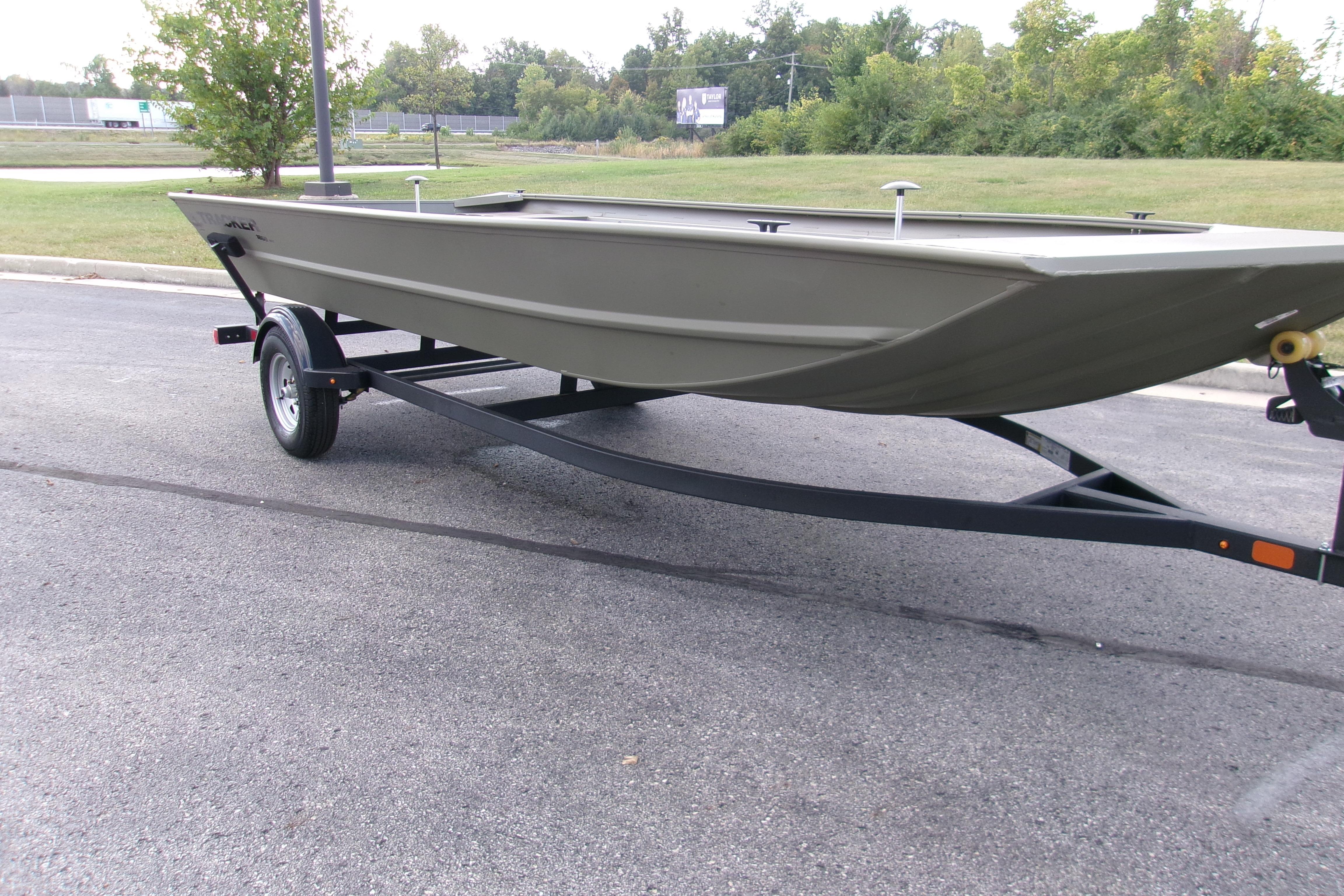 Tracker Grizzly 1860 Utility 2026 Tracker Grizzly 1860 Utility boat on trailer, parked on asphalt road.