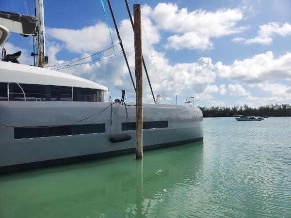 Lagoon SEVENTY 7 2020 Lagoon SEVENTY 7 catamaran docked in calm turquoise waters under a blue sky.