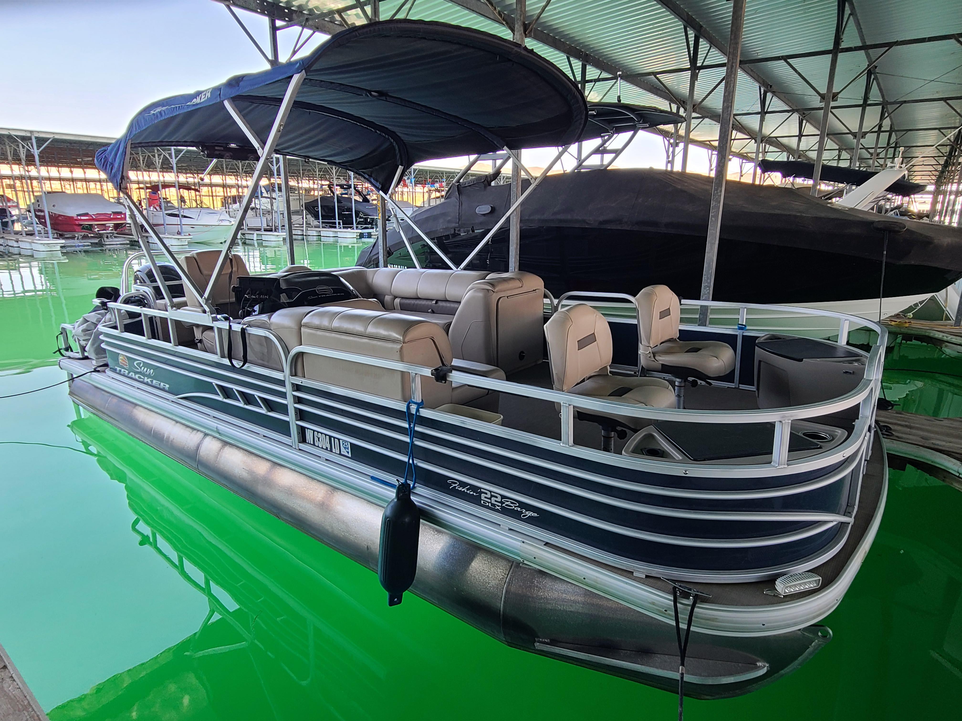 Sun Tracker 22 Fishin Barge 2021 Sun Tracker 22 Fishin Barge pontoon boat docked in a marina.
