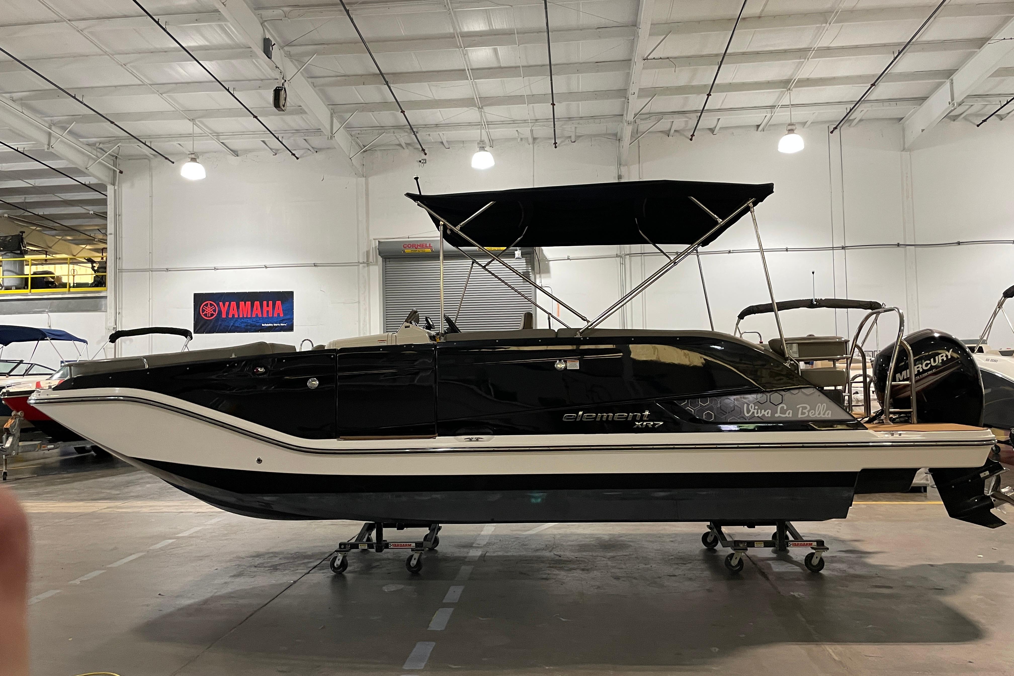 Bayliner Element XR7 2016 Bayliner Element XR7 boat in showroom, black and white design, under indoor lighting.
