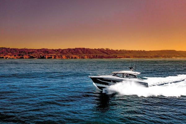 Prestige 420S Luxury Prestige 420S yacht cruising at sunset, 2025 model, near scenic coastline.