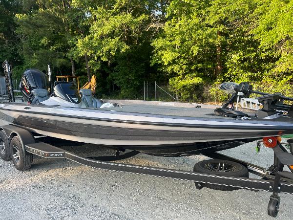 Skeeter ZXR 21 2025 Skeeter ZXR 21 boat on trailer, parked outdoors near trees.