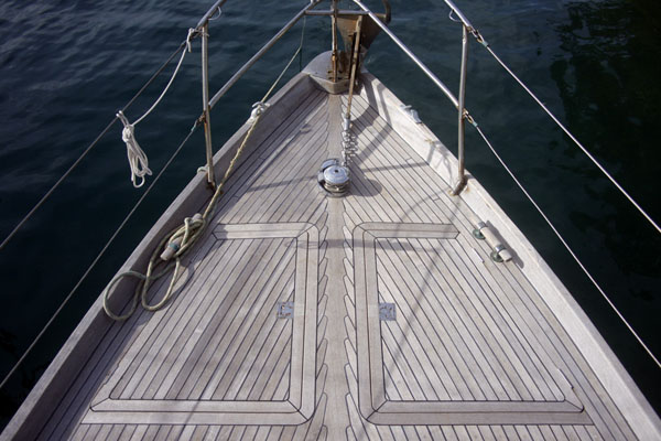A photo of the teak deck on the foredeck of a sailboat. 