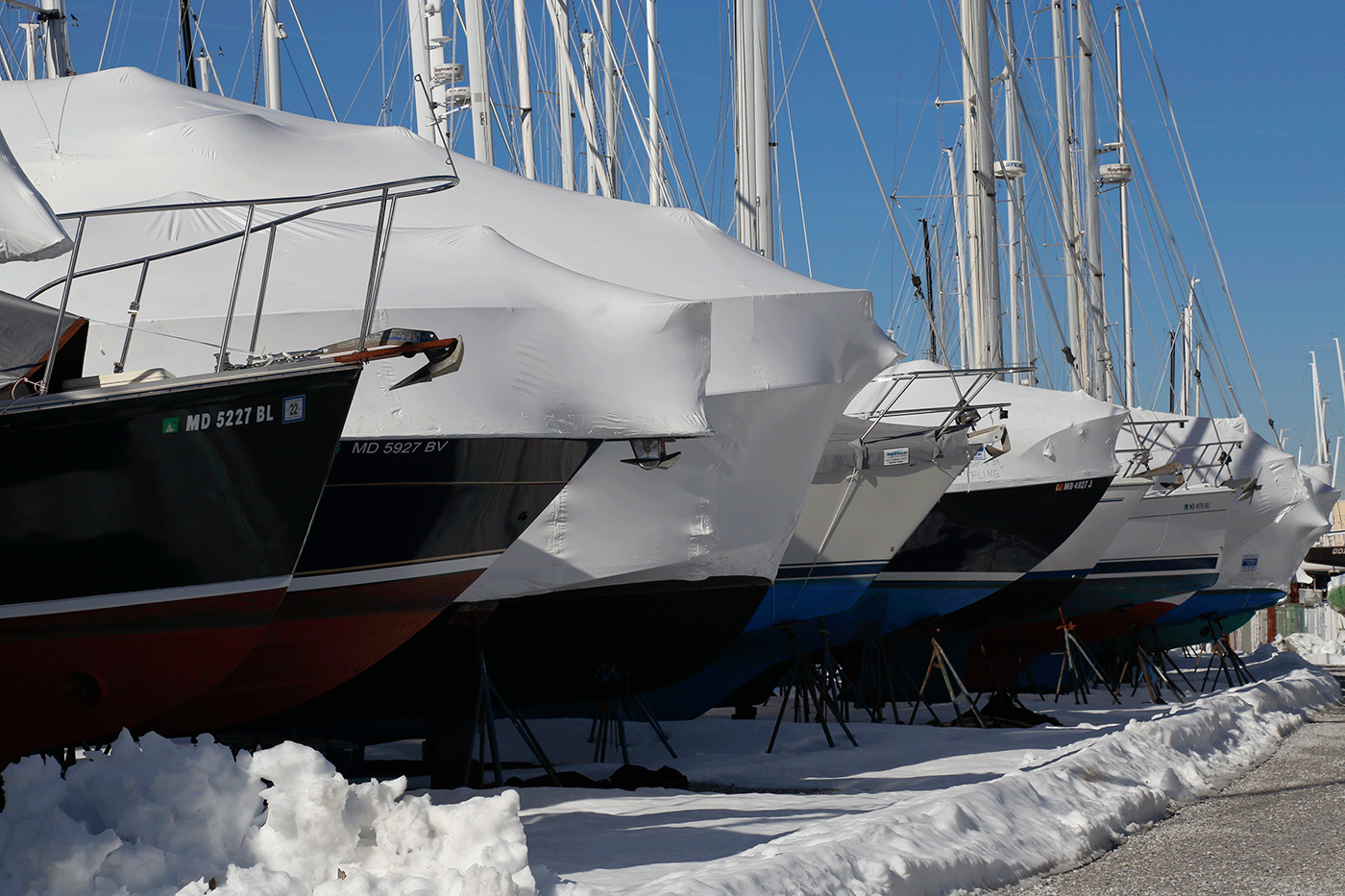 A row of covered boats await their grand unveiling come springtime.