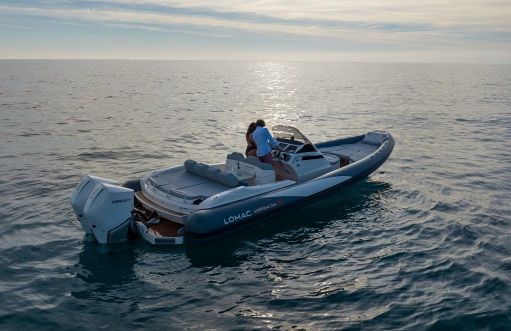 Un uomo e una donna su un RIB Lomac ancorato al tramonto.