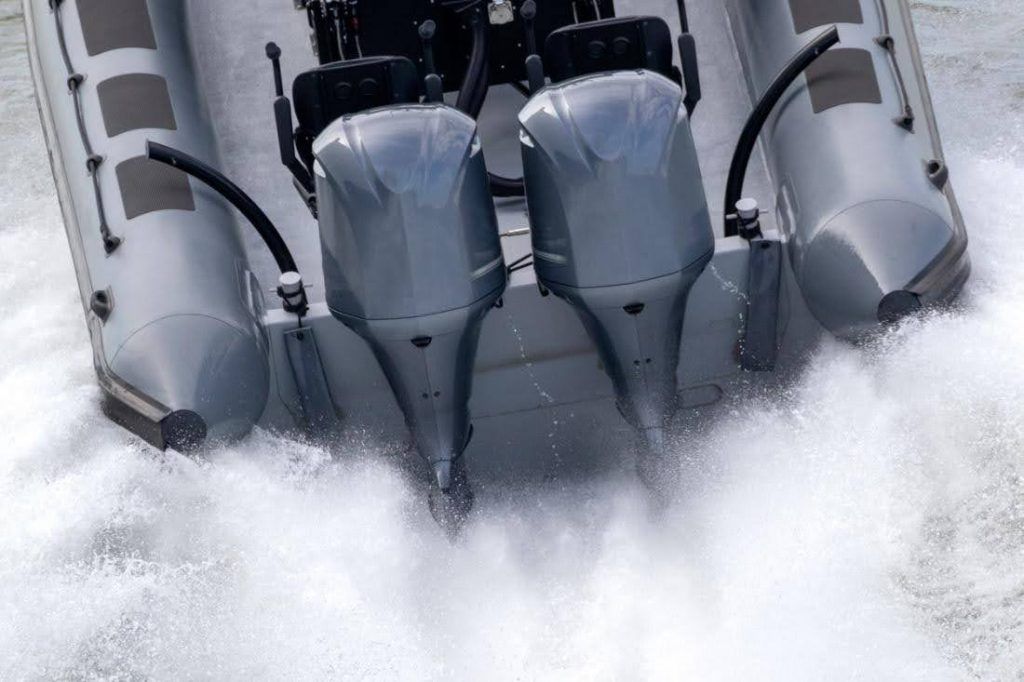 Krachtige buitenboordmotoren hangen achter een speedboot in actie.